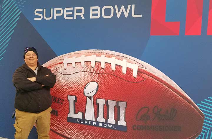 Mo stands in front of Super Bowl sign