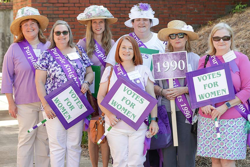 Class of 1990 hold signs that say Votes for Women.